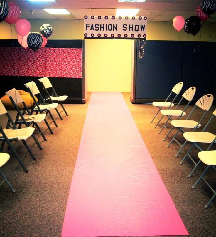 an empty fashion show room with chairs and a pink runner on the floor in front of it