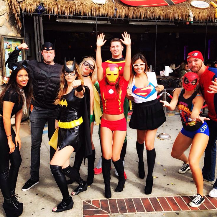 a group of people dressed up in costumes posing for the camera with their arms raised