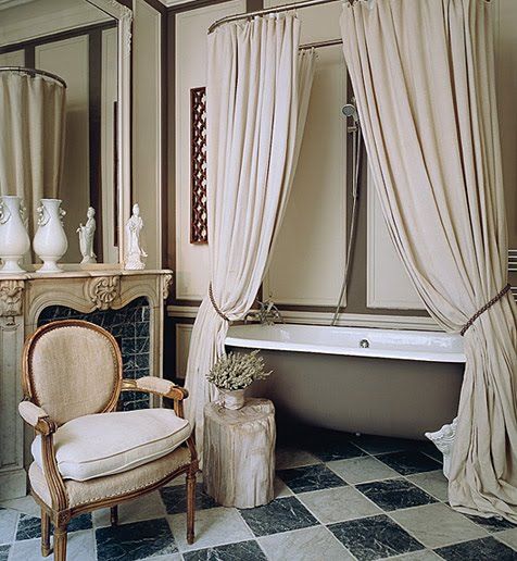 an old fashioned bathtub and chair in a room with checkered flooring on the walls