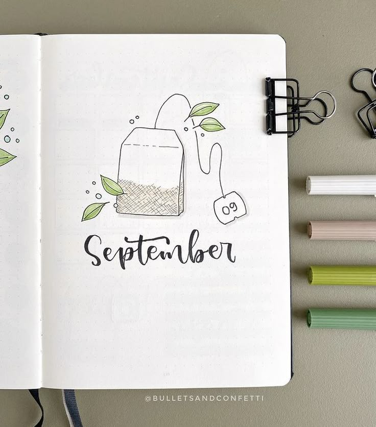 an open notebook with the words october written in black on it next to markers and pens