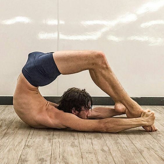 a man is doing a yoga pose on the floor