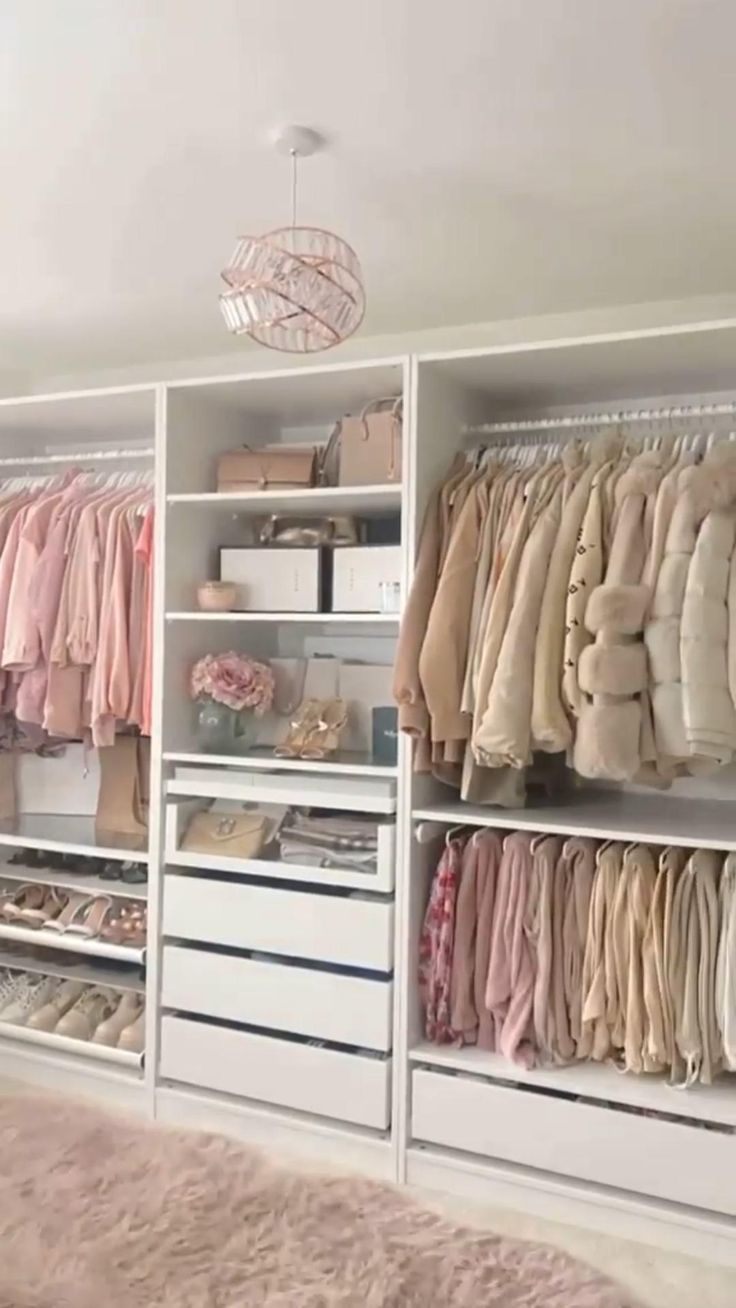 an organized closet with clothes and other items on shelving units, all in white