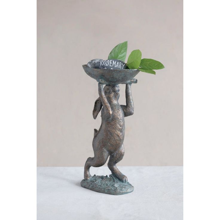 a statue holding a tray with leaves on it