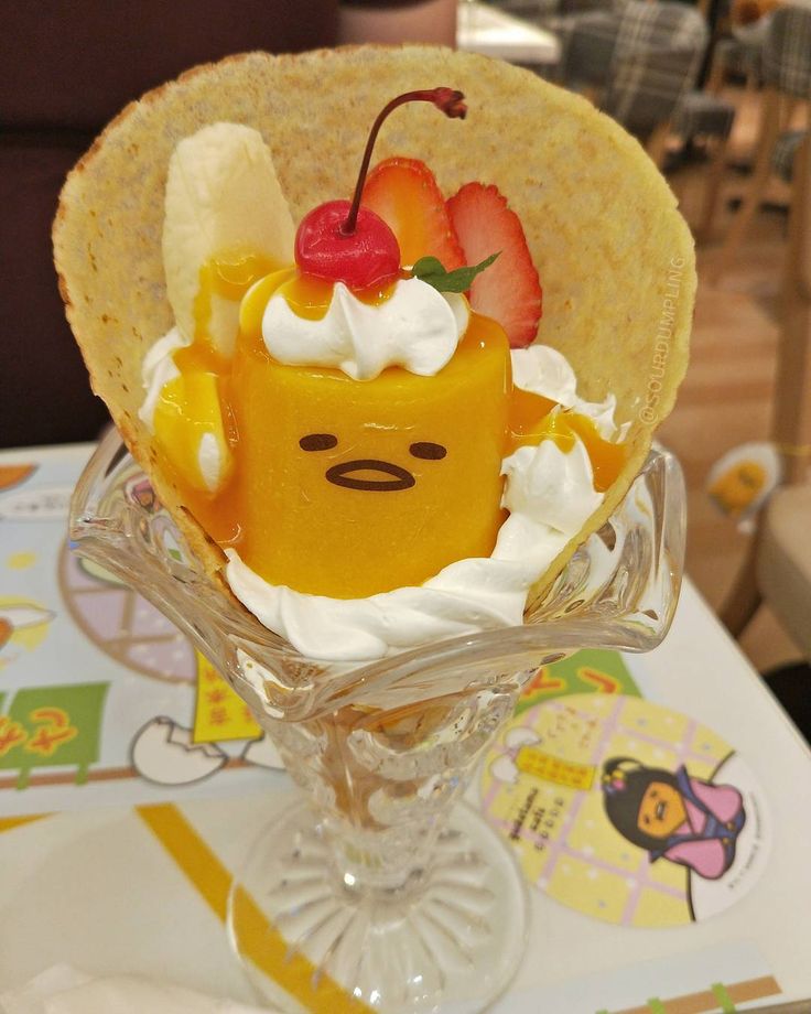 a dessert in a glass bowl with fruit on top