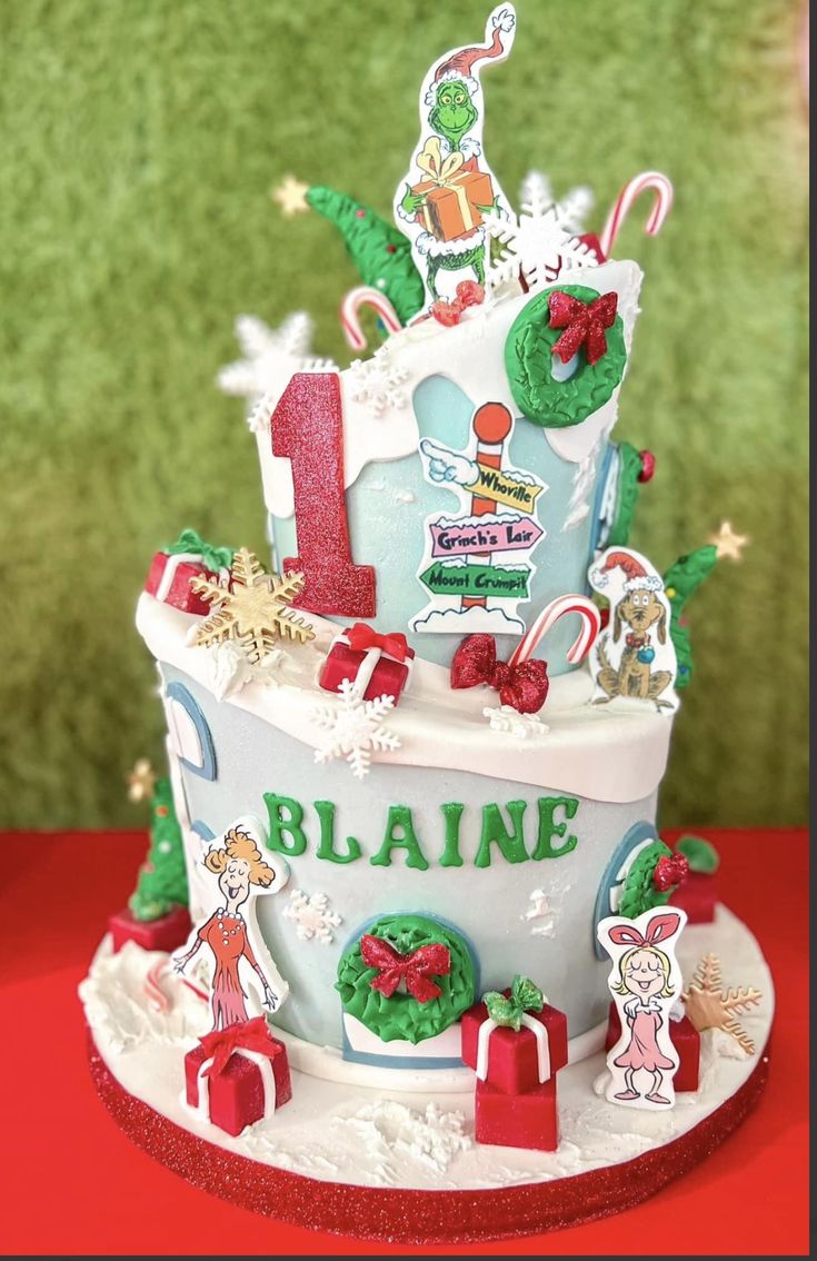 a three tiered cake decorated with christmas decorations and candy canes is on a red table