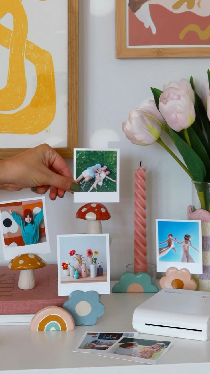 a table topped with pictures and flowers next to a vase filled with tulips