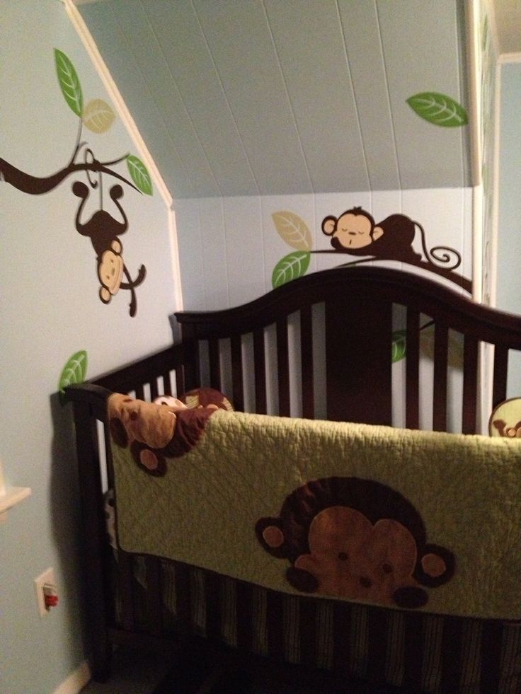 a baby crib with monkeys and leaves on it