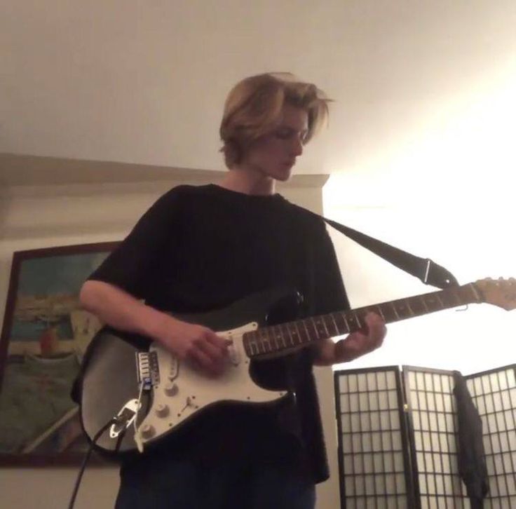 a young man is playing an electric guitar