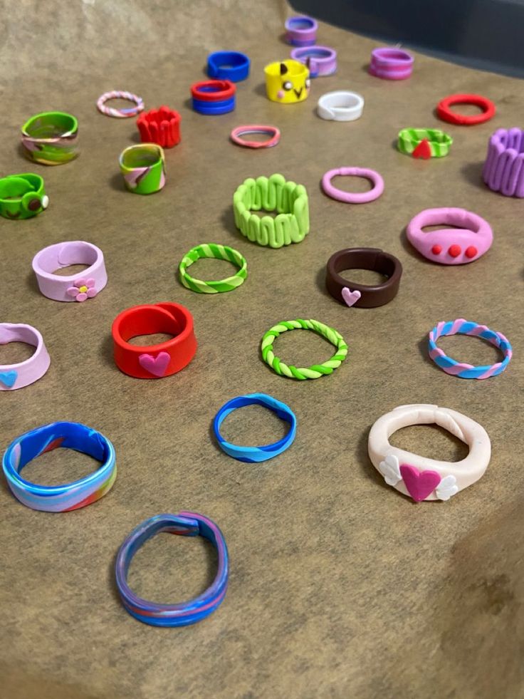 many different colored rings and bracelets on a table