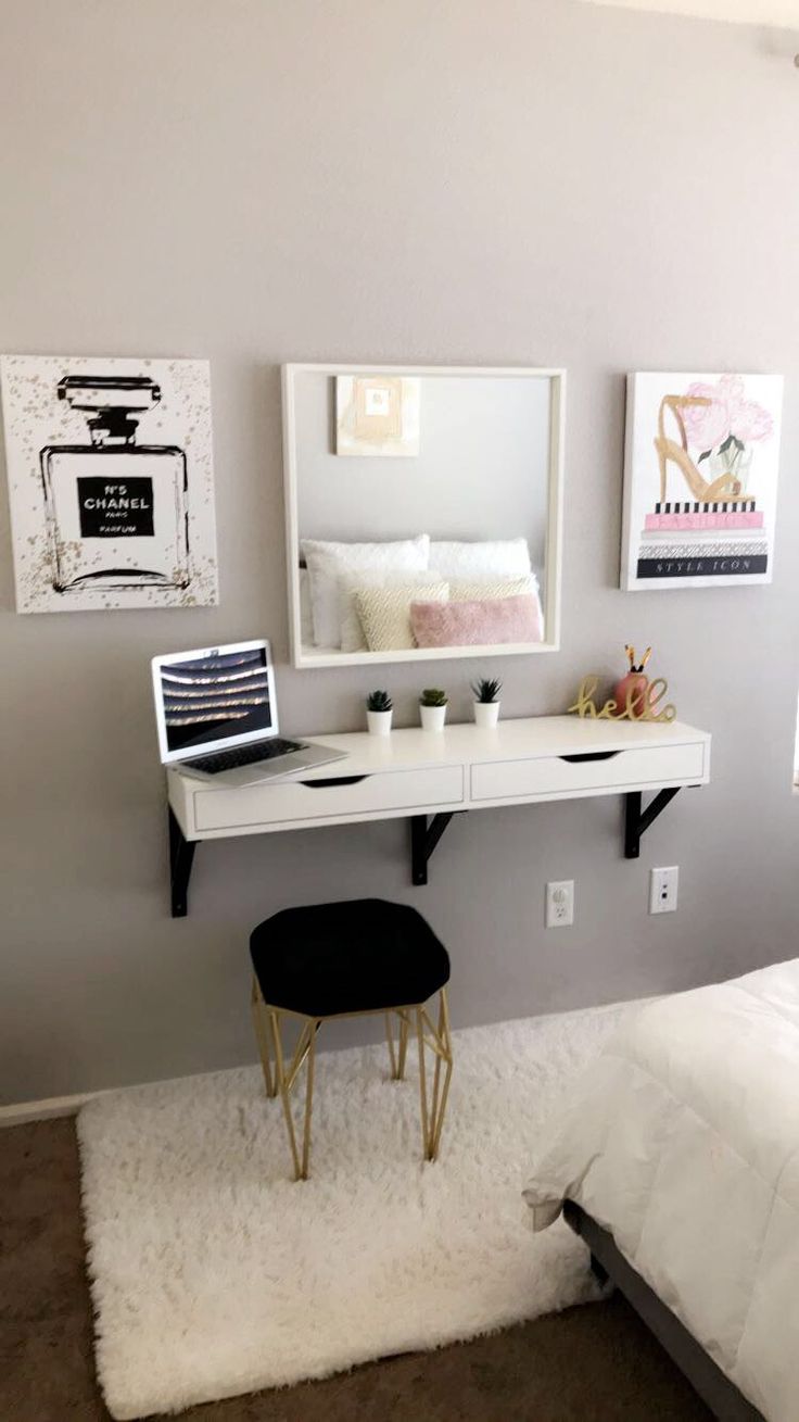 a bedroom with a bed, desk and mirror on the wall next to each other