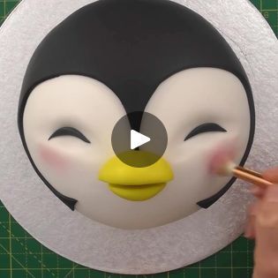 a penguin face cake being made with fondant