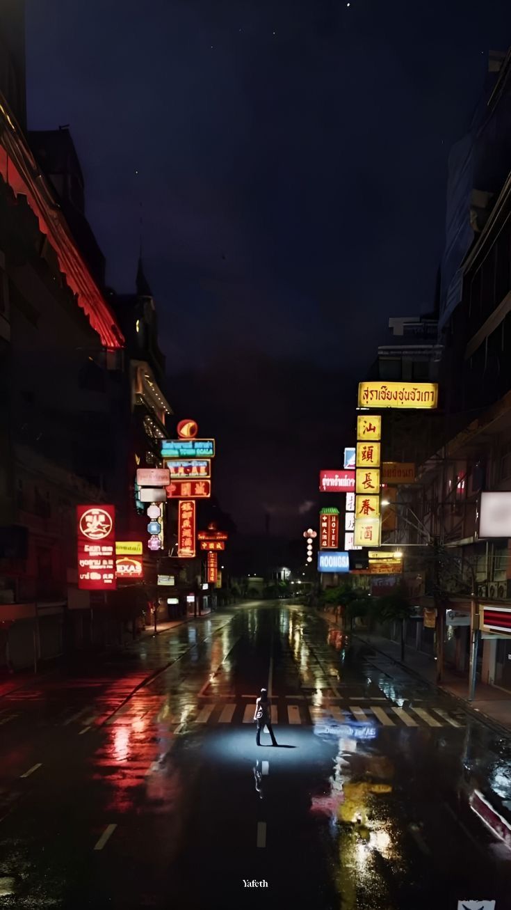 a city street at night with neon signs on the buildings and people walking in the rain