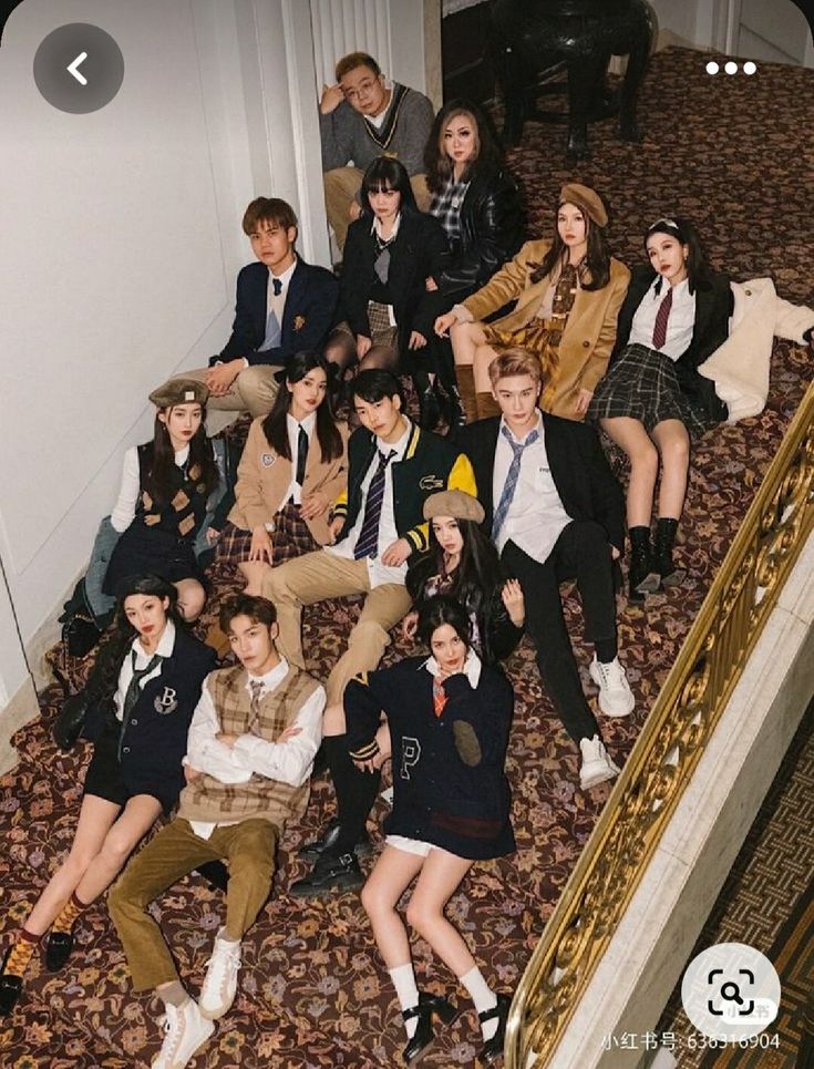 a group of young people posing for a photo in front of a stair case with their legs up