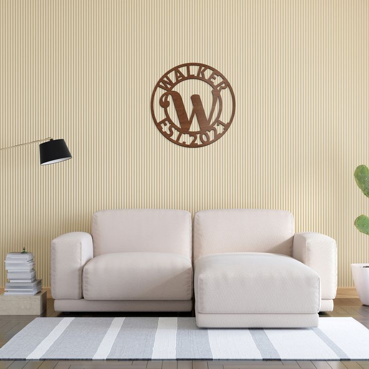 a white couch sitting on top of a hard wood floor next to a wall mounted clock