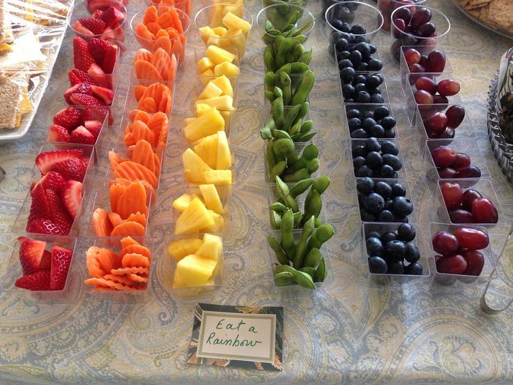 there are many different types of fruit on display in plastic trays at the table