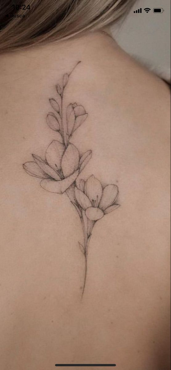 the back of a woman's neck with flowers on it