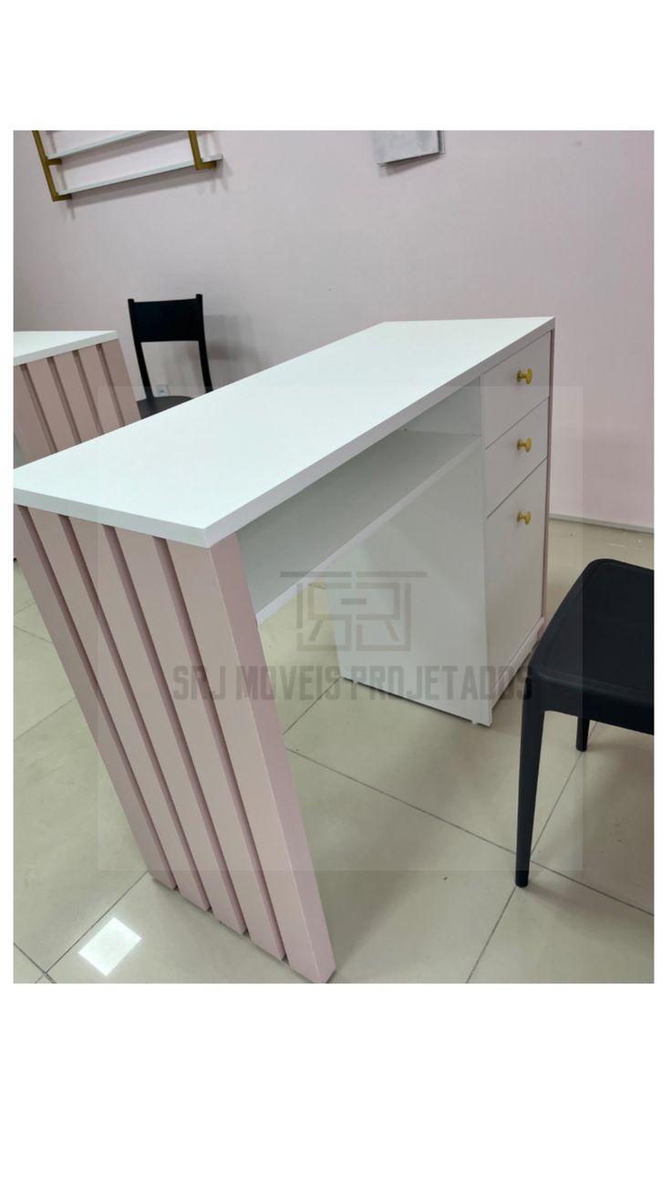 an office desk with two chairs and a white counter top in front of a pink wall