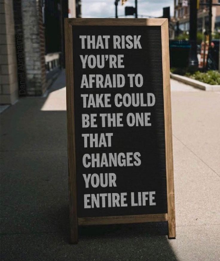 a sign on the sidewalk that says, that risk you're afraid to take could be the one that changes your entire life