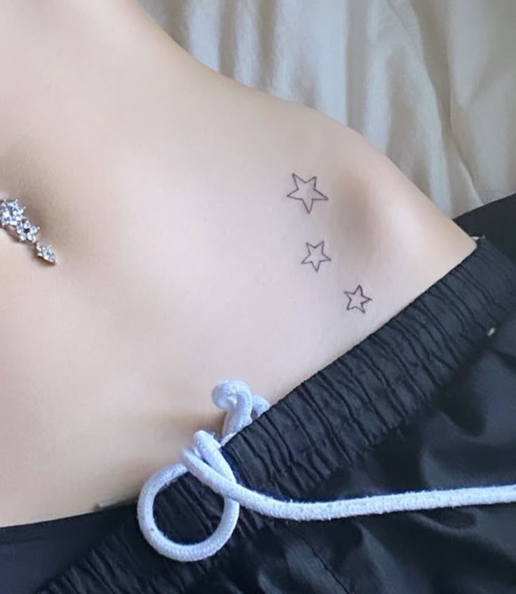 a woman's stomach with stars on it and a white string attached to the side