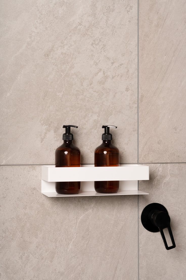 two brown bottles sitting on top of a white shelf