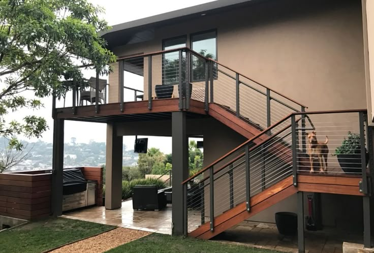 a couple of people that are standing in front of a house with some stairs on it