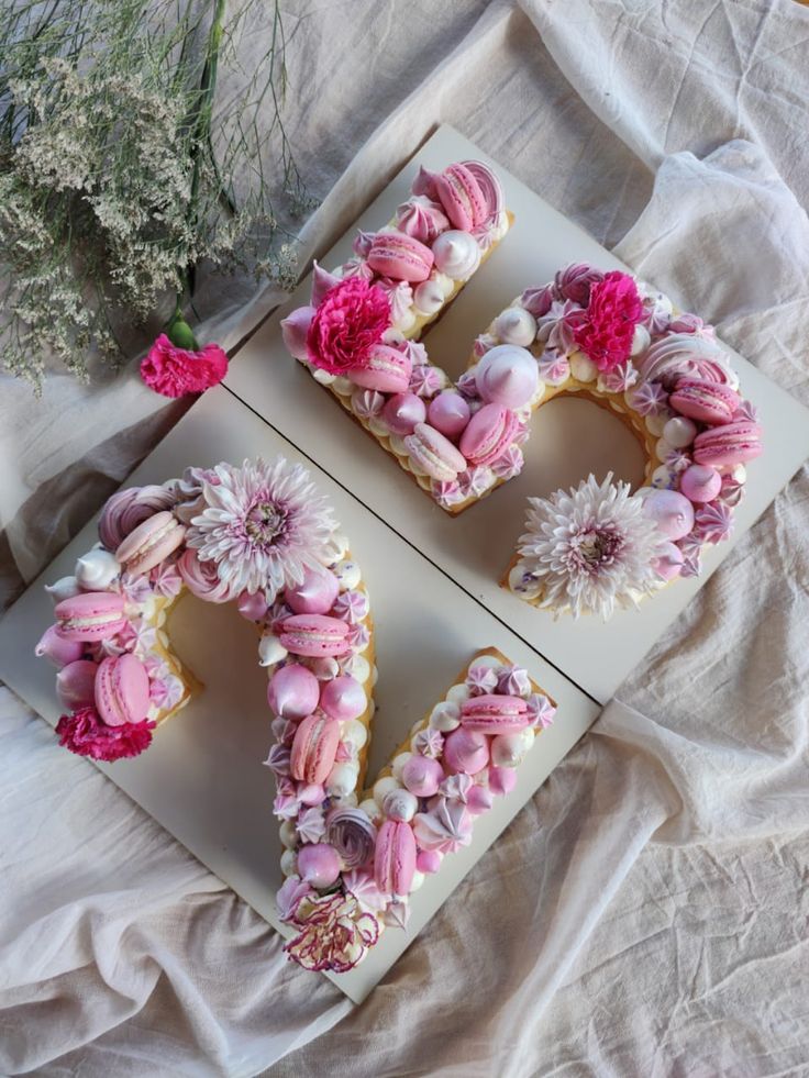 the letters are decorated with pink flowers and marshmallows in the shape of love