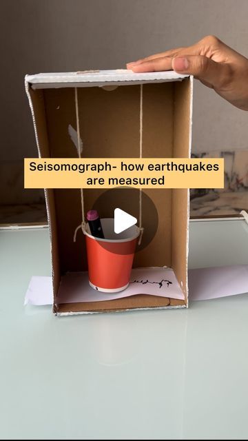 someone is opening up a cardboard box with an empty cup in it and the words seismonograph how earthfukes are measured