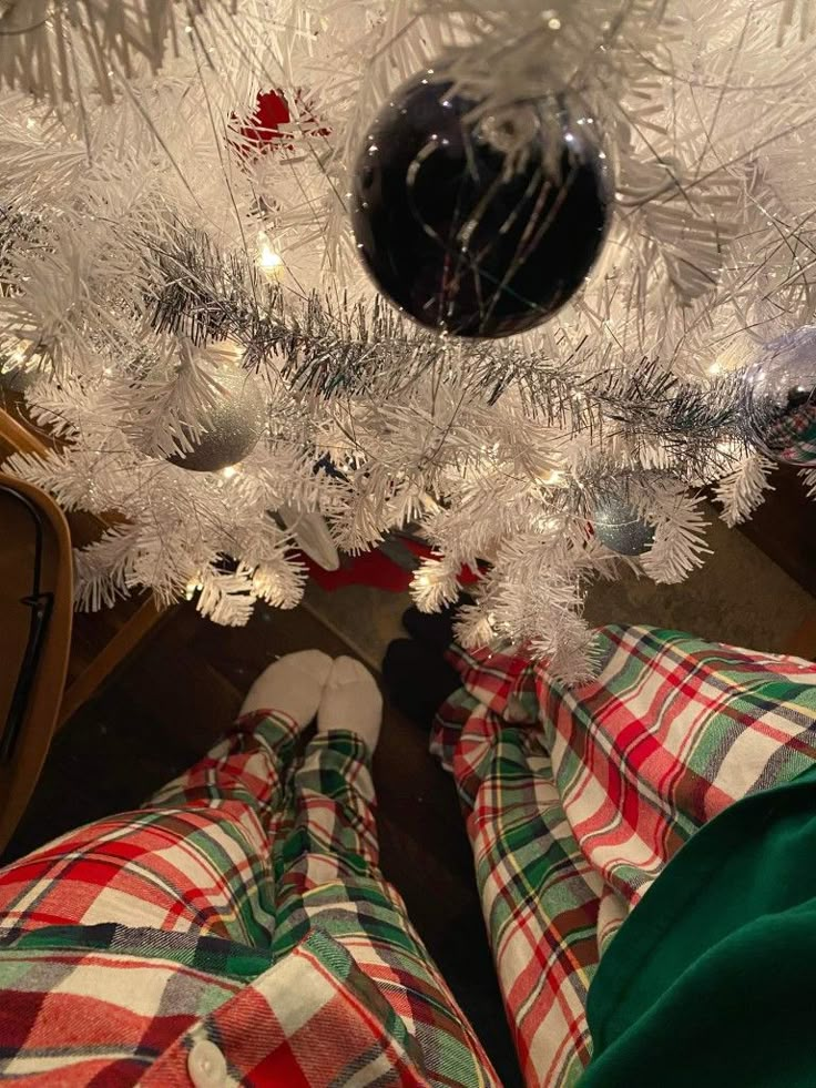 a person standing underneath a white christmas tree