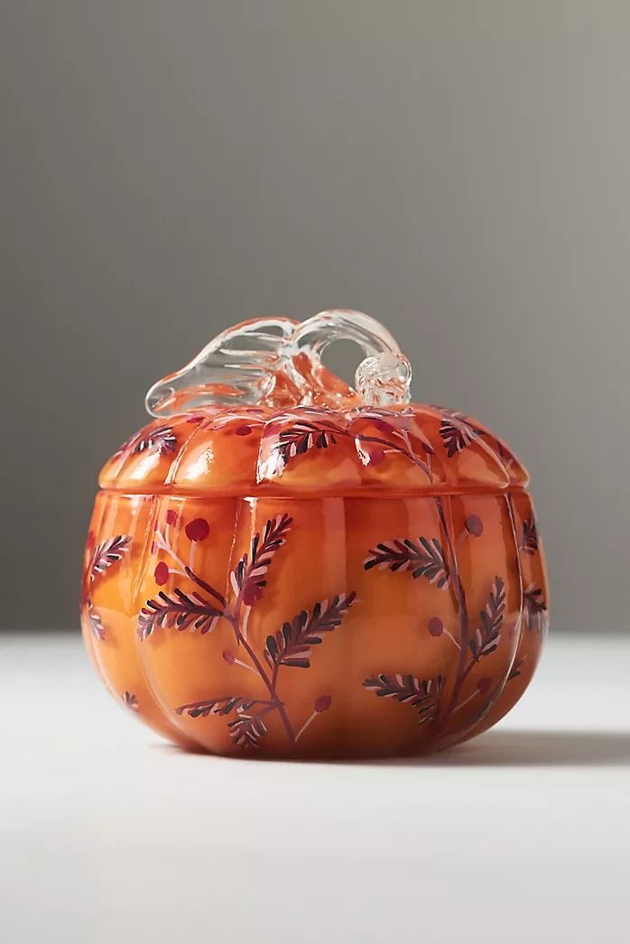 an orange glass bowl with leaves on it