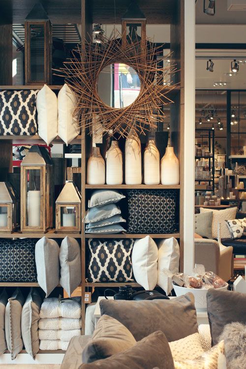 a living room filled with lots of furniture and decor on top of a wooden shelf