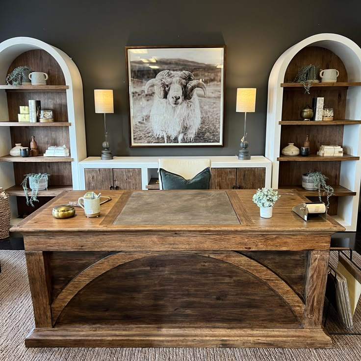 a large wooden table sitting inside of a living room next to a book shelf filled with books