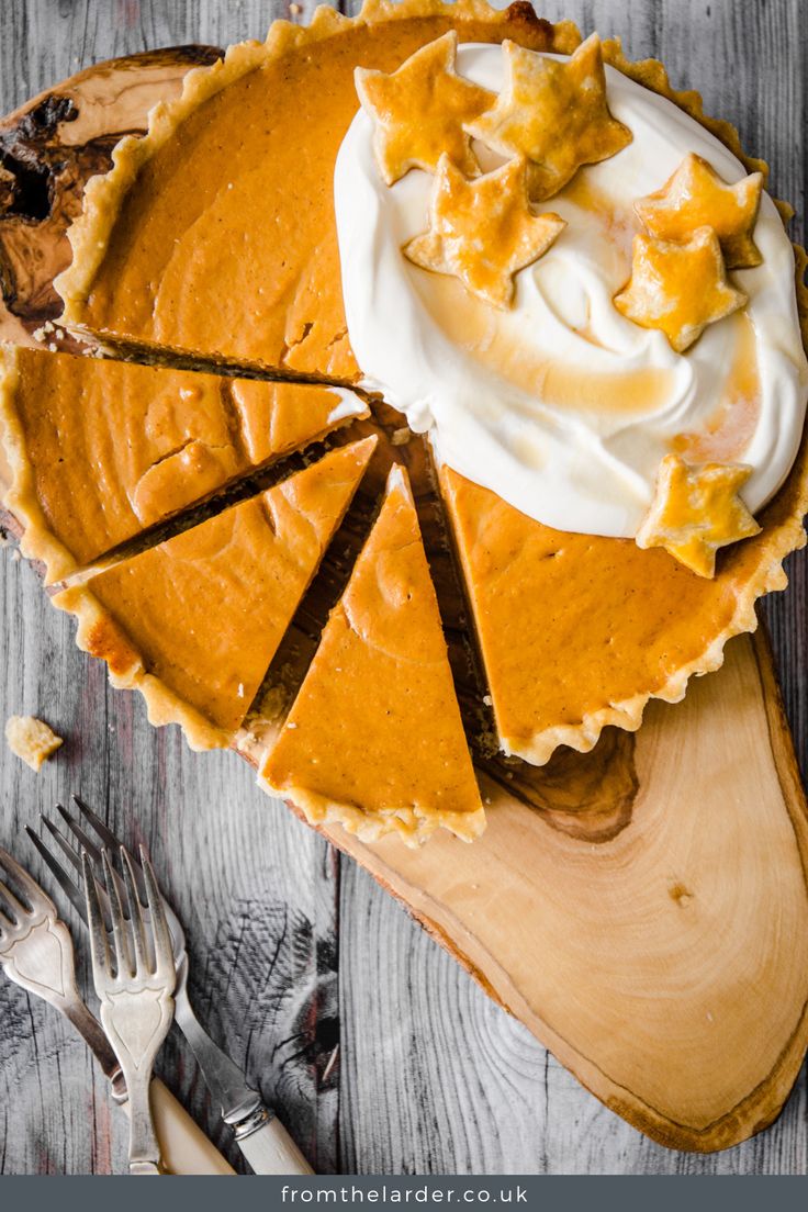 a pumpkin pie with whipped cream on top and slices cut out to show the filling