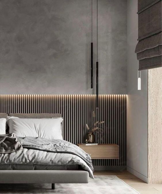 a modern bedroom with grey walls and white bedding, black headboard and pillows