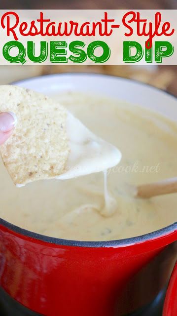 a hand holding a tortilla chip over a red pot filled with quesadilla dip