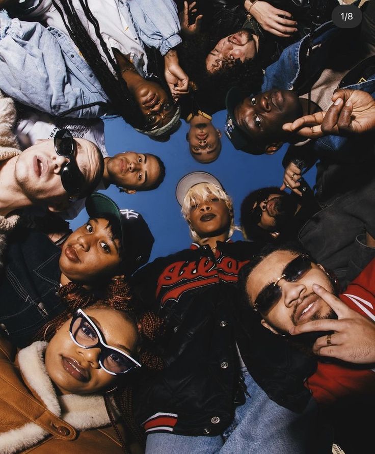 a group of people standing in a circle with their hands together and looking up at the camera