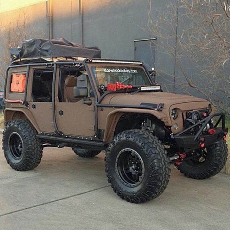 a brown jeep parked in front of a building