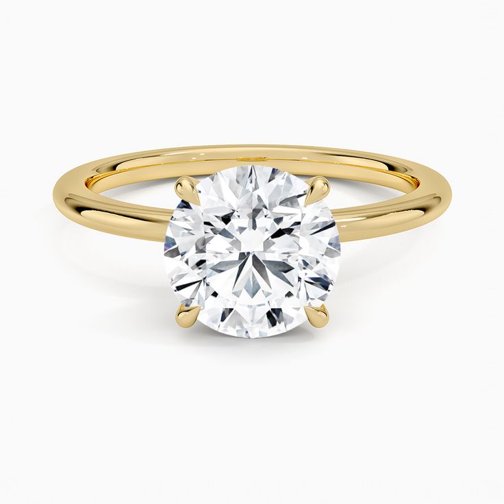 a yellow gold engagement ring with a round brilliant cut diamond in the center, on a white background