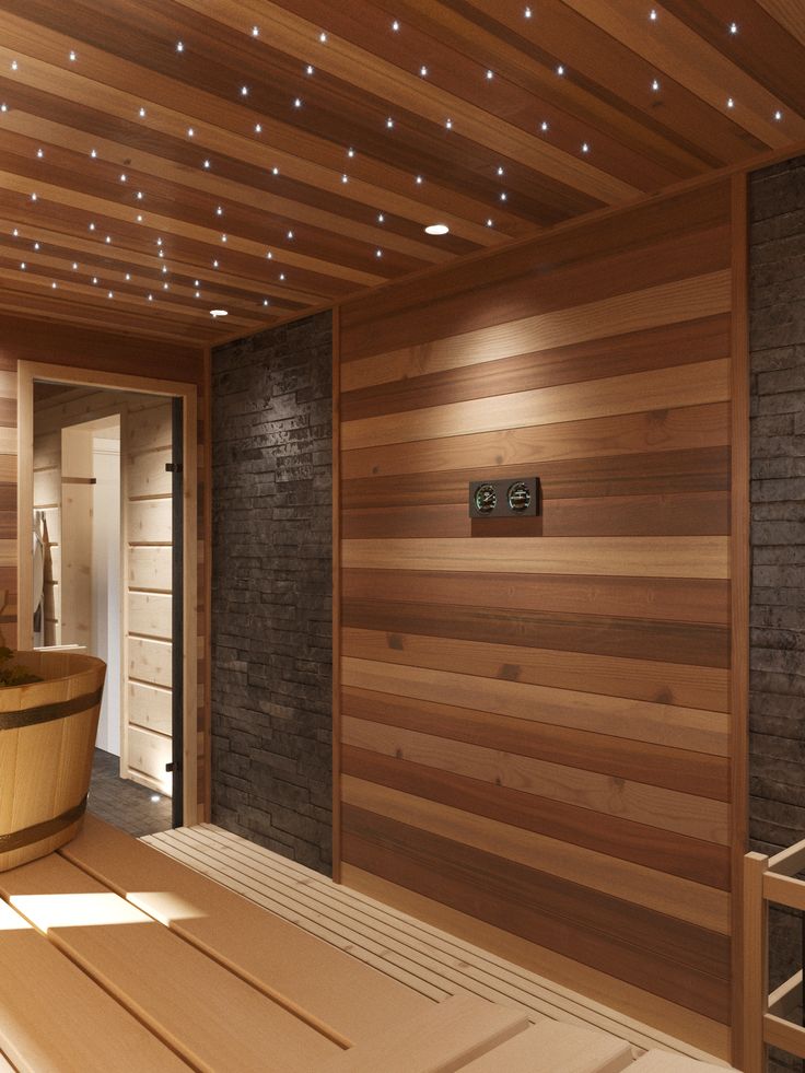 a large wooden bath tub sitting inside of a bathroom next to a brick wall with lights on the ceiling