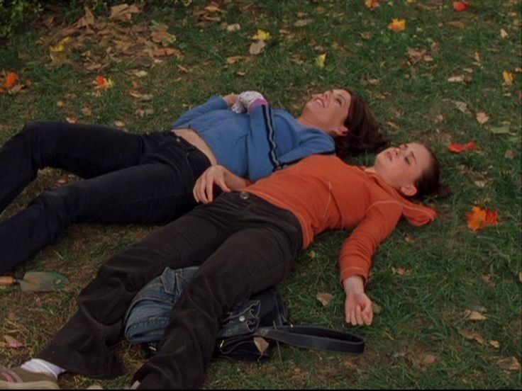 two people laying on the ground next to each other