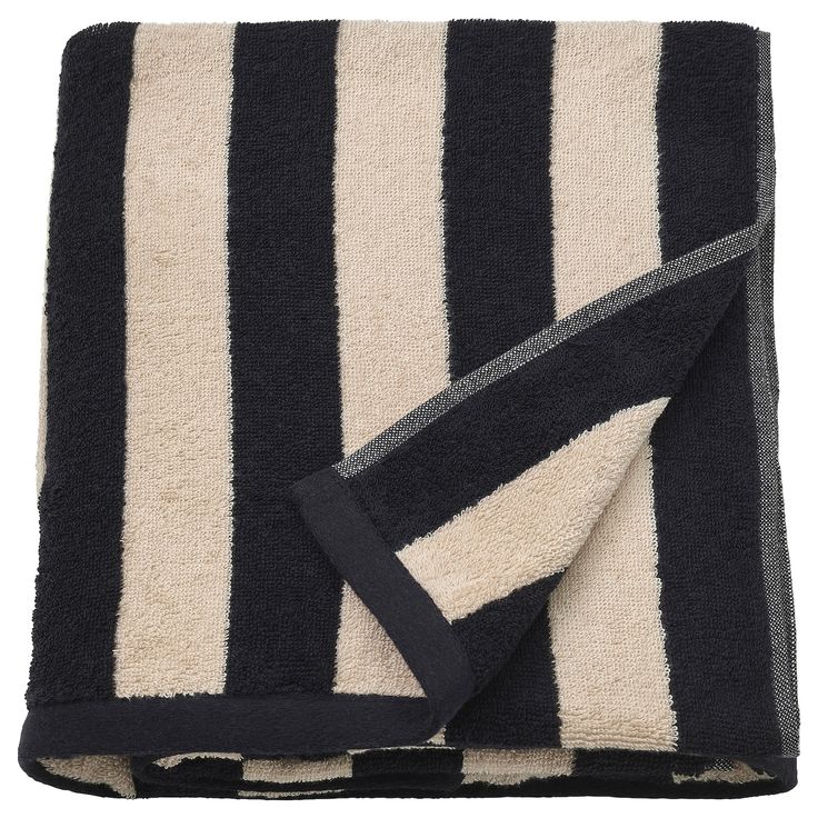 the black and white striped towel is folded on top of it's own blanket