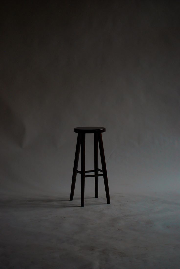 a black stool sitting on top of a white floor