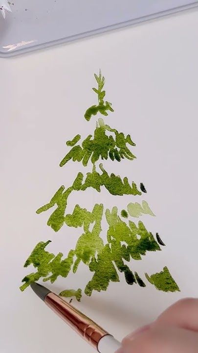 someone is drawing a christmas tree with green paint on white paper and brown pencils