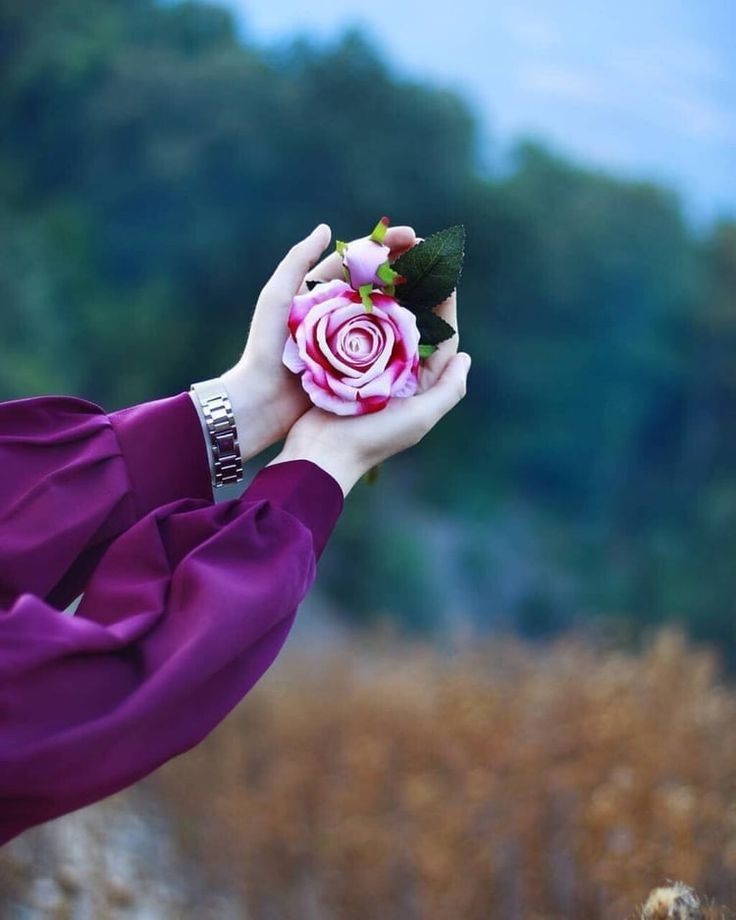 a close up of a person holding a flower