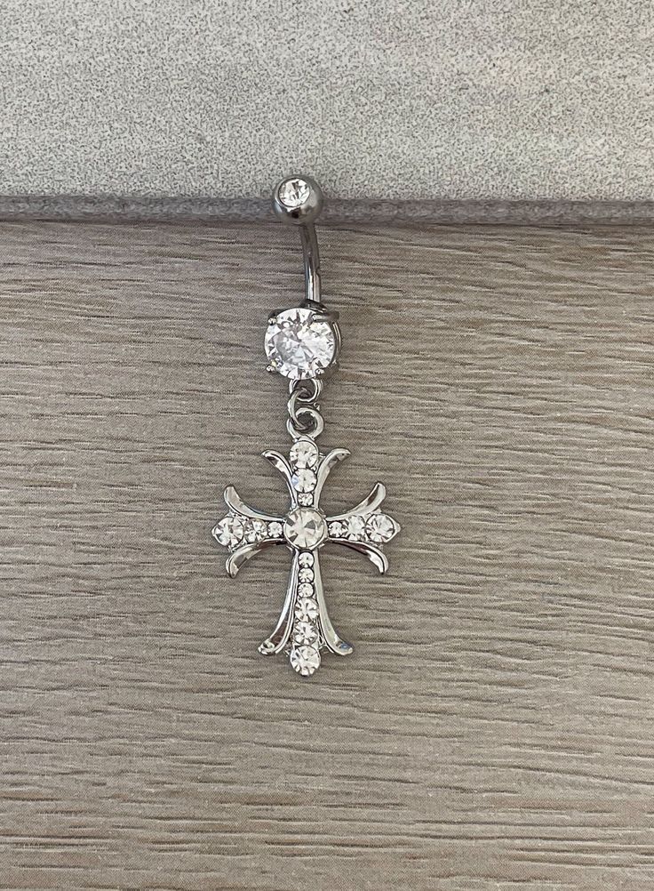 the cross is attached to an earring with crystal stones on it's side