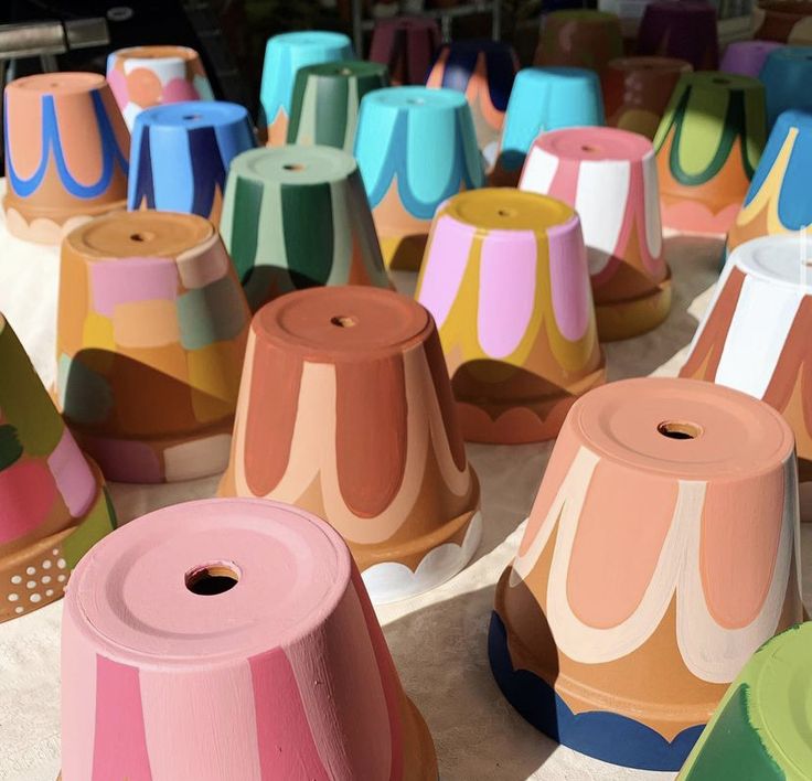 many different colored vases are sitting on the table together, with one being rolled up