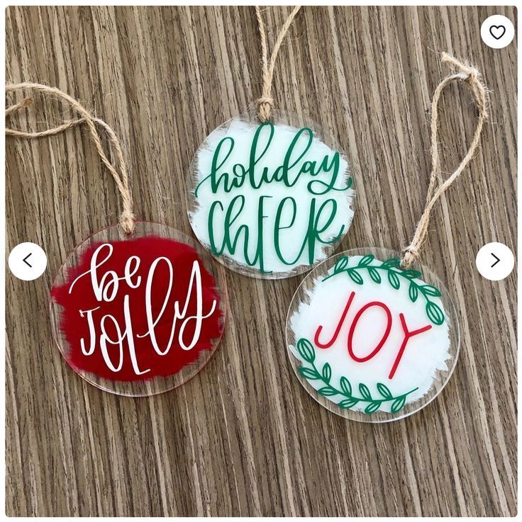 three christmas ornaments hanging from strings on a wooden table with the words holiday walk written in red, white and green