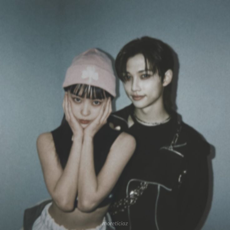 two young women posing for a photo with their hands on their face and one wearing a pink hat