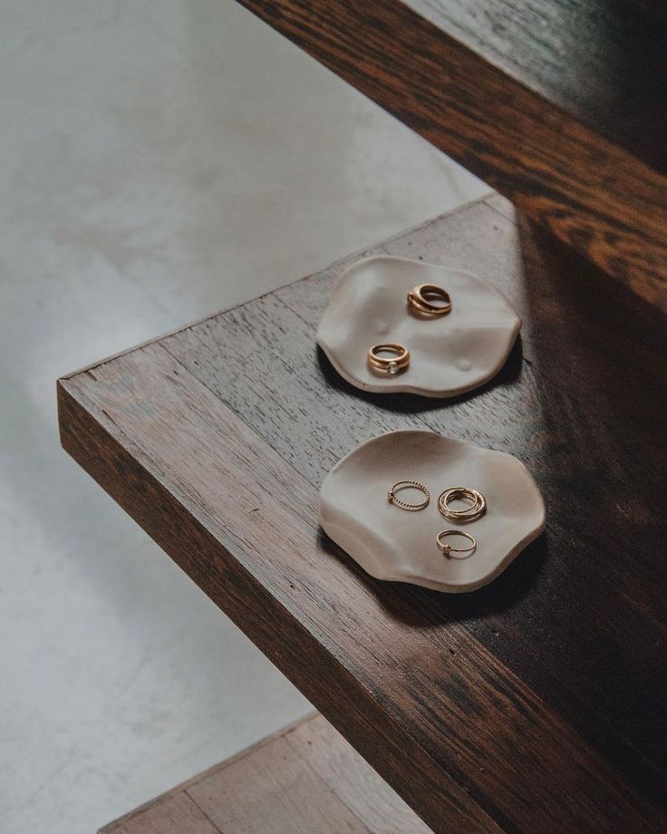 two ceramic buttons sitting on top of a wooden table next to each other in front of a mirror