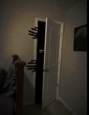 an open door with black hands coming out of it