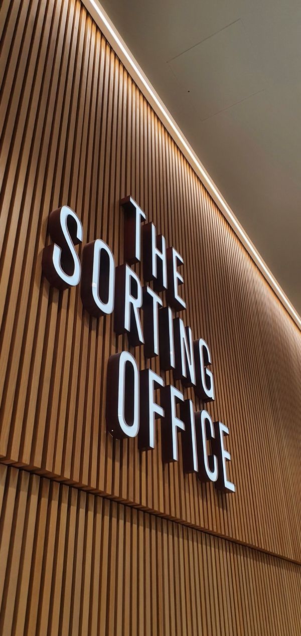 the sorting office sign is lit up on the wall